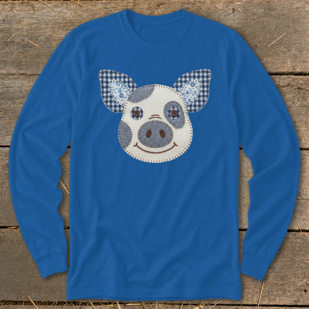Blue long-sleeve shirt with a patchwork pig face applique and checkered ears.