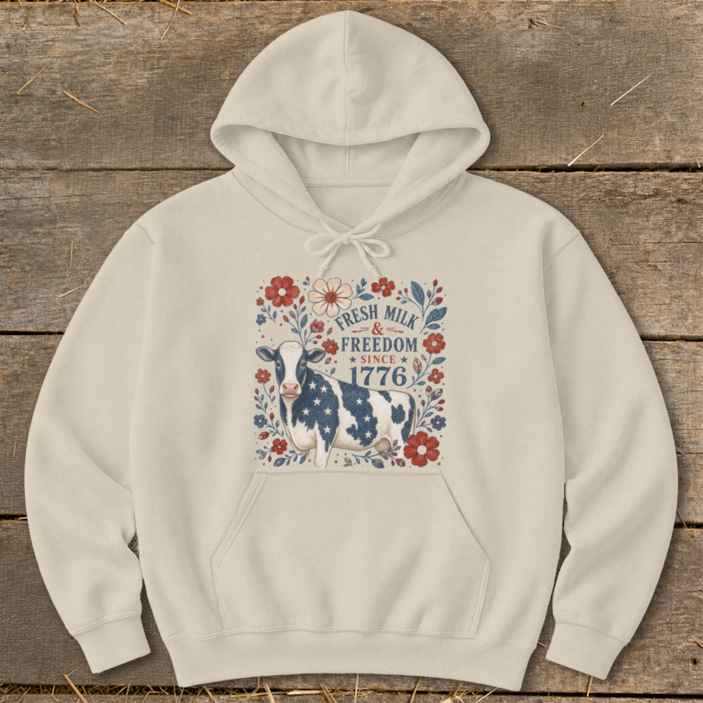 Cream hoodie with cow, flowers, and text: "Fresh Milk & Freedom Since 1776."