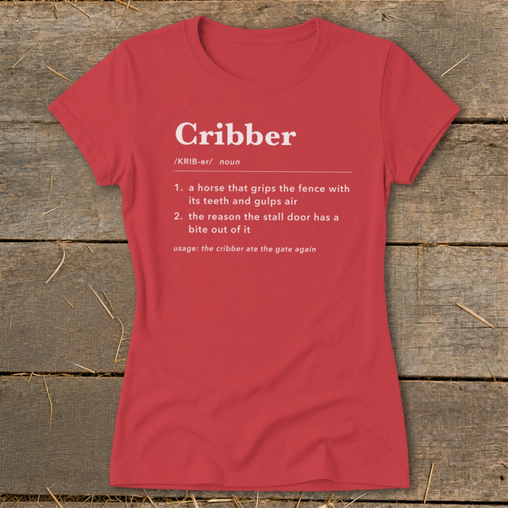 A red women's t-shirt printed with a humorous dictionary definition of the word Cribber in white text.