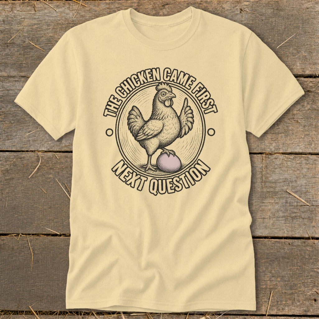 Light yellow t-shirt with a chicken on an egg, saying "The chicken came first. Next question."