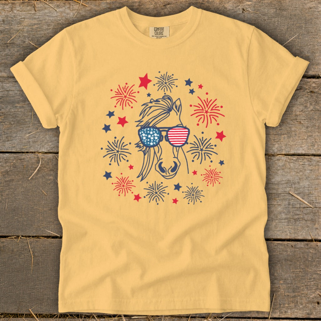 Yellow t-shirt with horse wearing American flag sunglasses, surrounded by fireworks and stars.