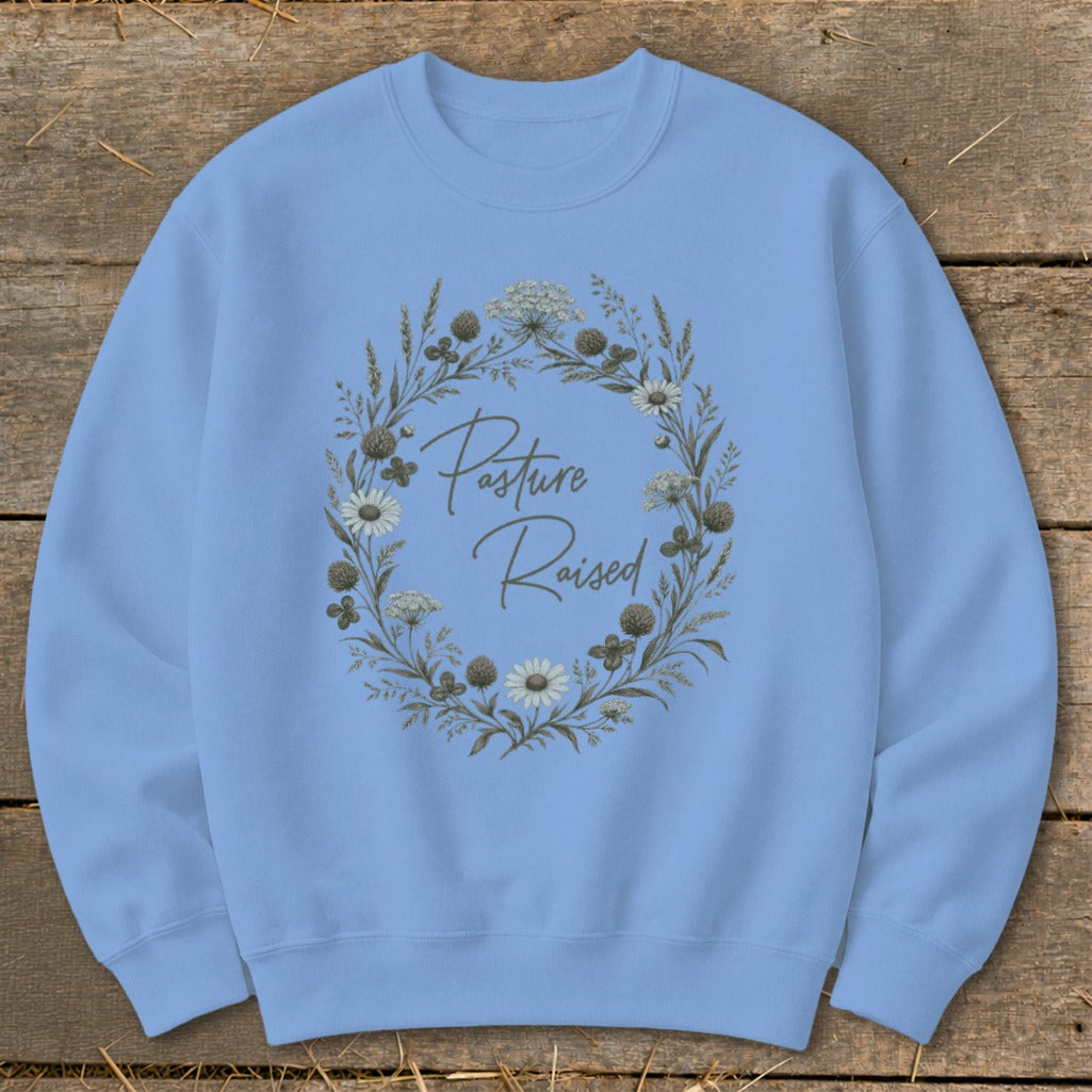 Light blue sweatshirt with "Pasture Raised" text in a floral wreath design.