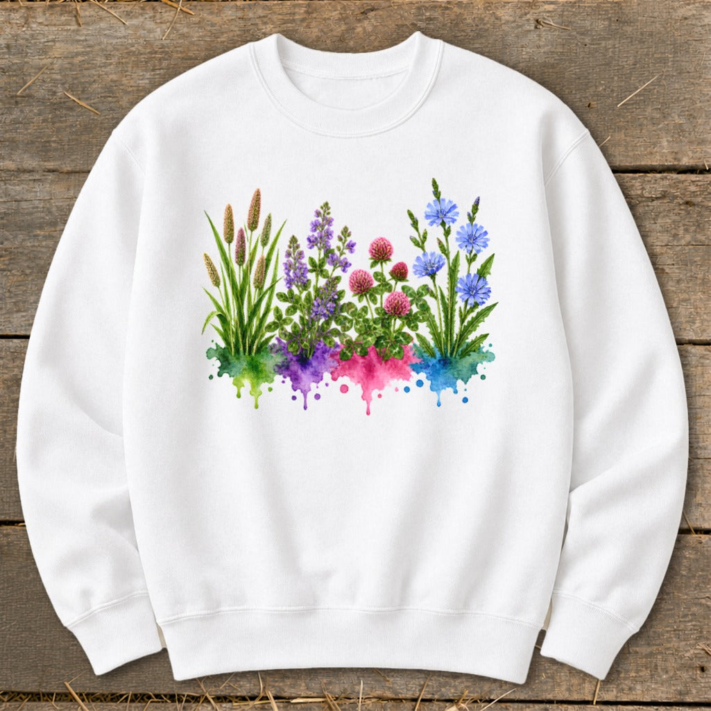 A white crewneck sweatshirt features a central graphic of colorful wildflowers emerging from watercolor splashes.