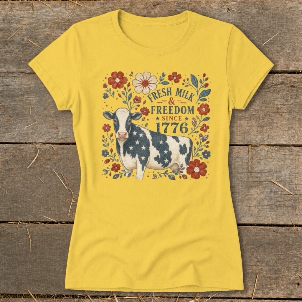Cow with American flag pattern on yellow t-shirt, text reads "Fresh Milk & Freedom Since 1776".