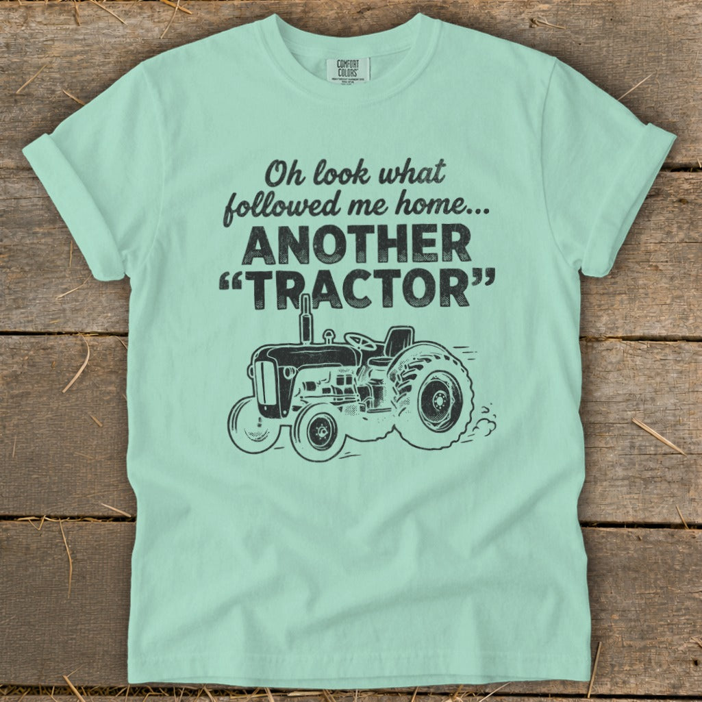 Light blue t-shirt with text "Oh look what followed me home... ANOTHER 'TRACTOR'" and a tractor graphic.