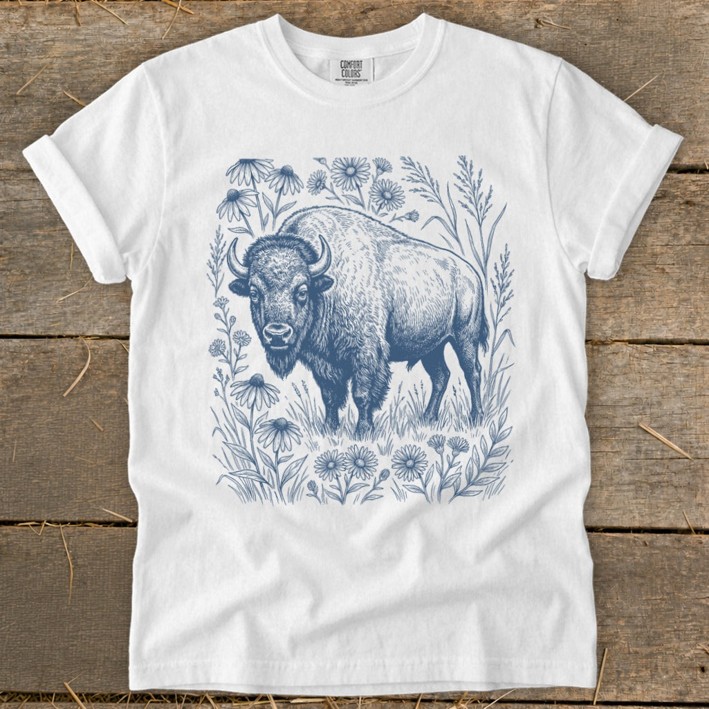 White t-shirt with a blue ink drawing of a bison surrounded by wildflowers.