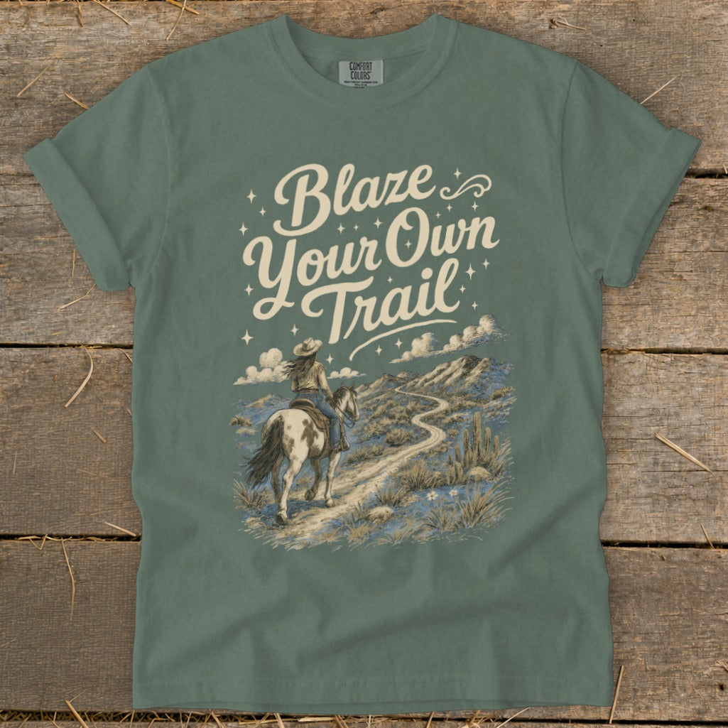 T-shirt with "Blaze Your Own Trail" text and a woman riding a horse through a desert landscape.