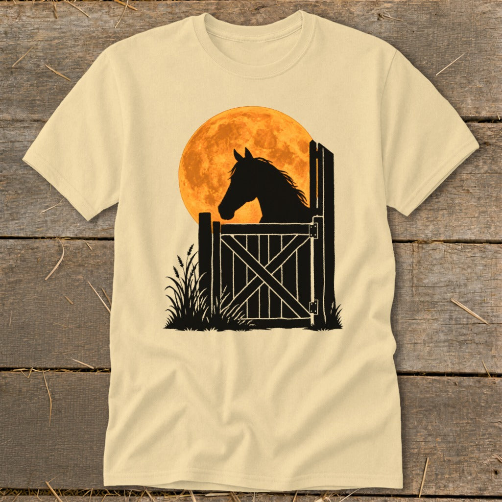 A cream-colored t-shirt with a graphic of a horse's silhouette at a stable gate against an orange moon.