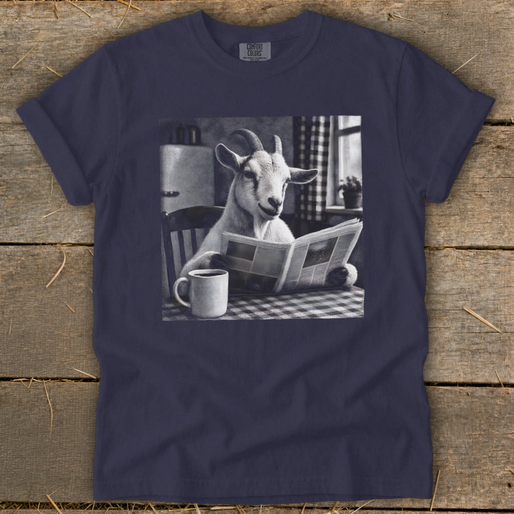 Navy blue t-shirt featuring a black and white graphic of a goat reading a newspaper at a table with a coffee mug.