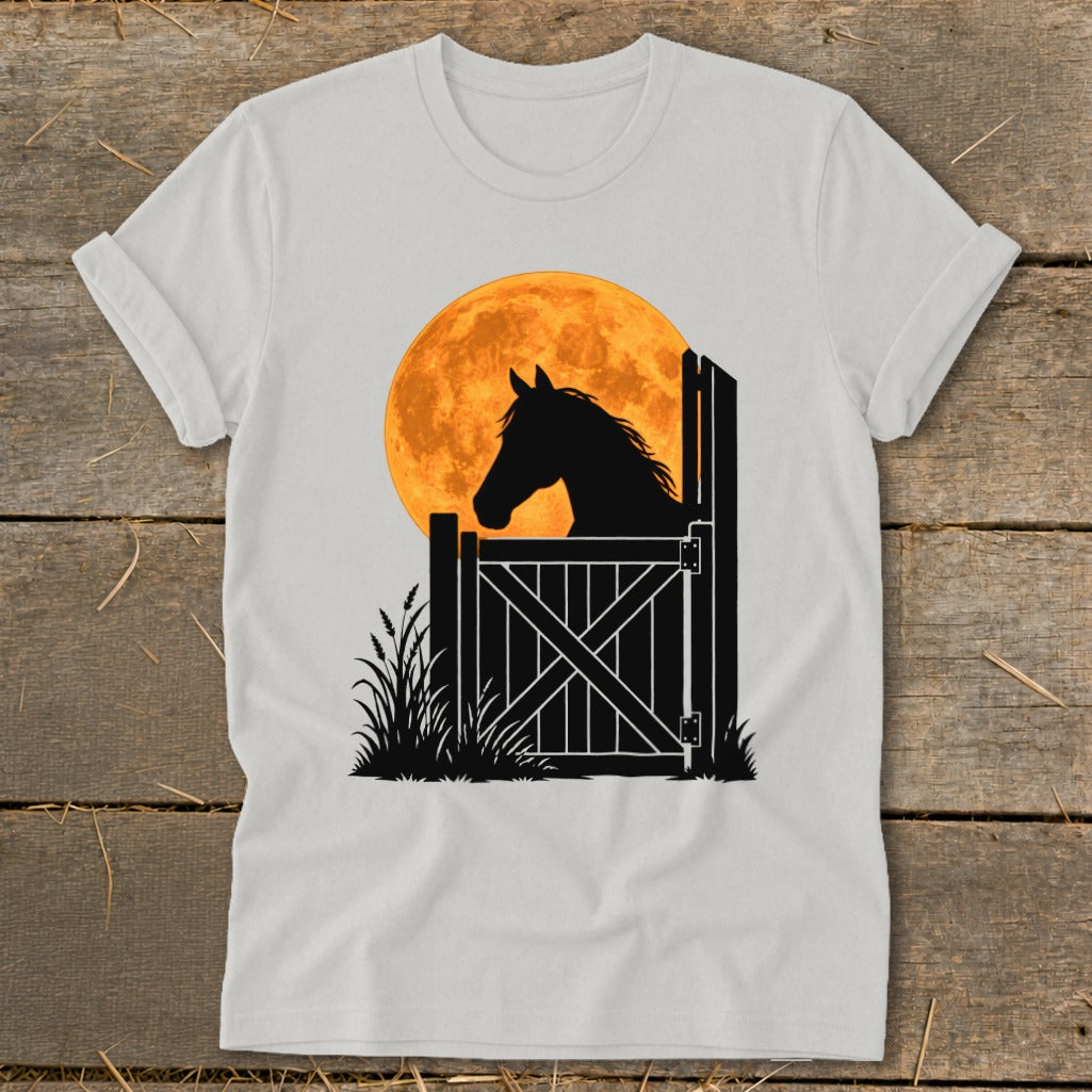 A light gray t-shirt featuring a graphic of a horse's silhouette looking over a stable door against an orange moon.