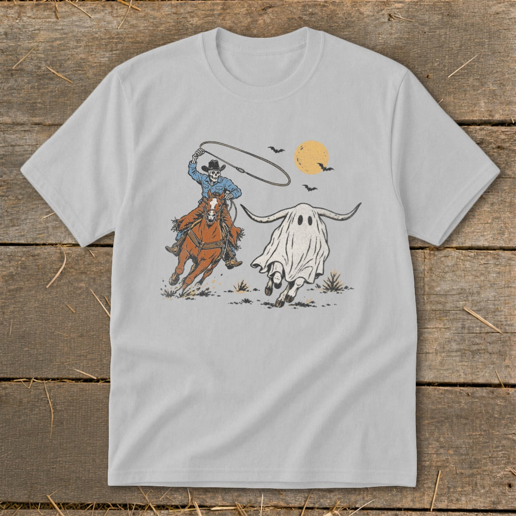 Skeleton cowboy on horse chasing a ghost with bull horns under a pale moon.