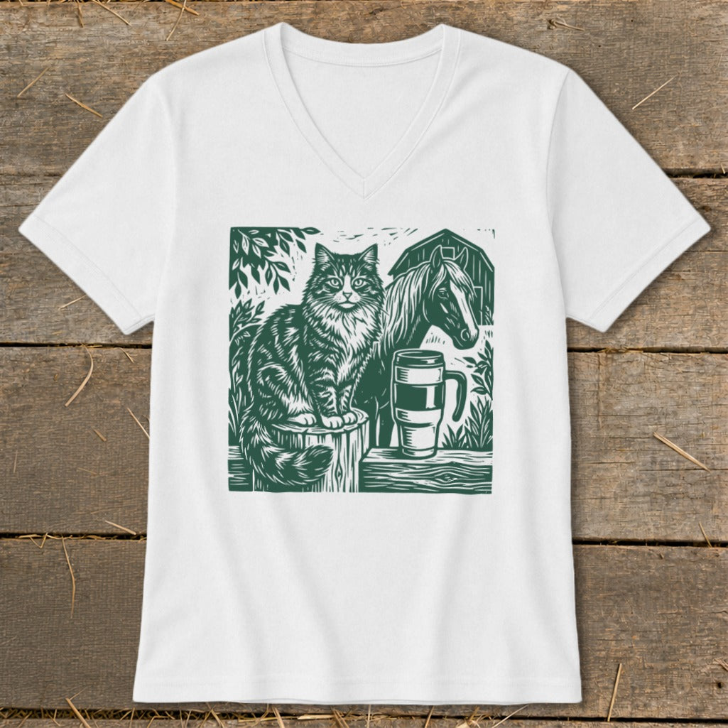 Green linocut art of a cat, horse, barn, and coffee mug on a white t-shirt.