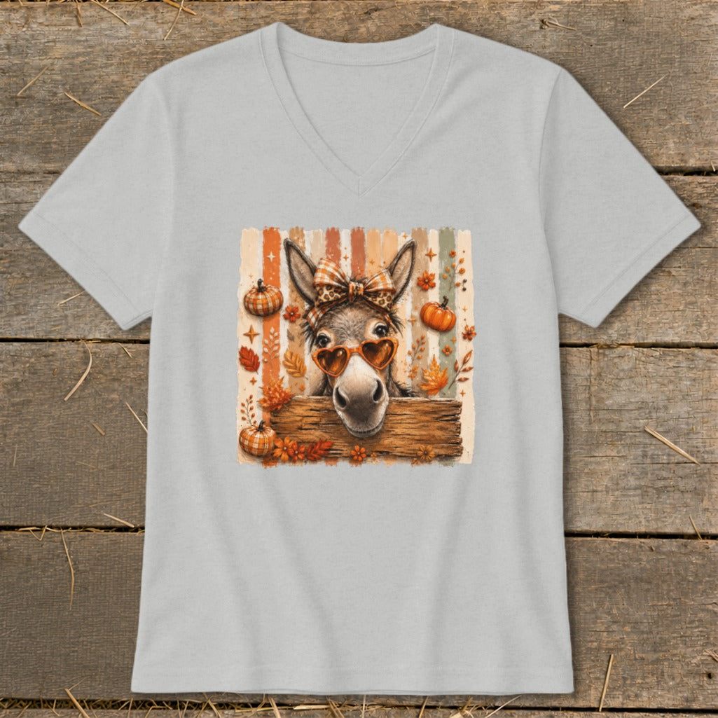 Donkey wearing heart sunglasses and bow on pastel striped background with pumpkins.