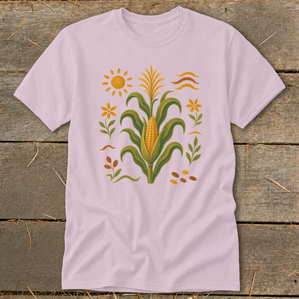 Pink t-shirt with a corn stalk, sun, flowers, and seeds graphic.