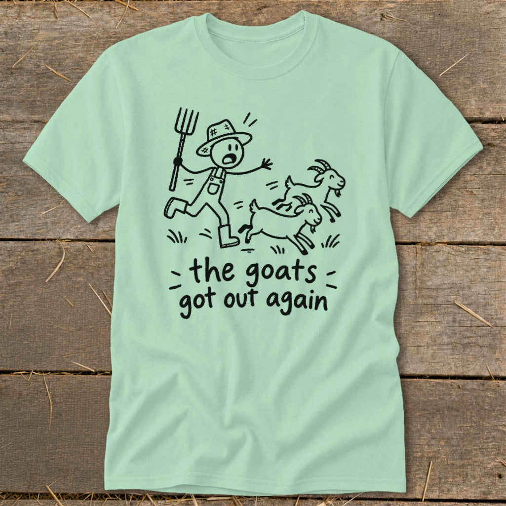 Light green t-shirt with a cartoon of a farmer chasing three goats, text reads "the goats got out again".