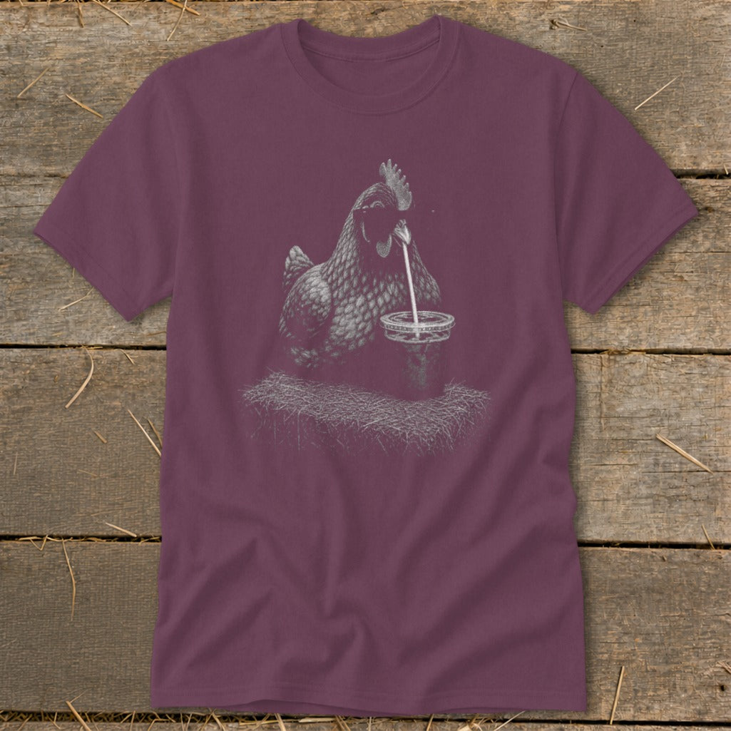T-shirt graphic of a chicken drinking from a cup on hay.