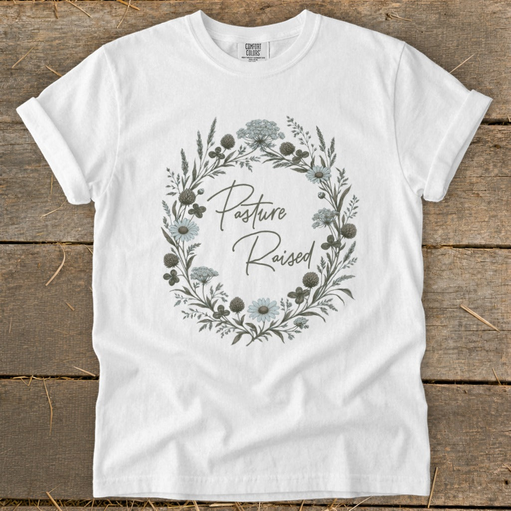 White t-shirt with "Pasture Raised" text in a floral wreath design.