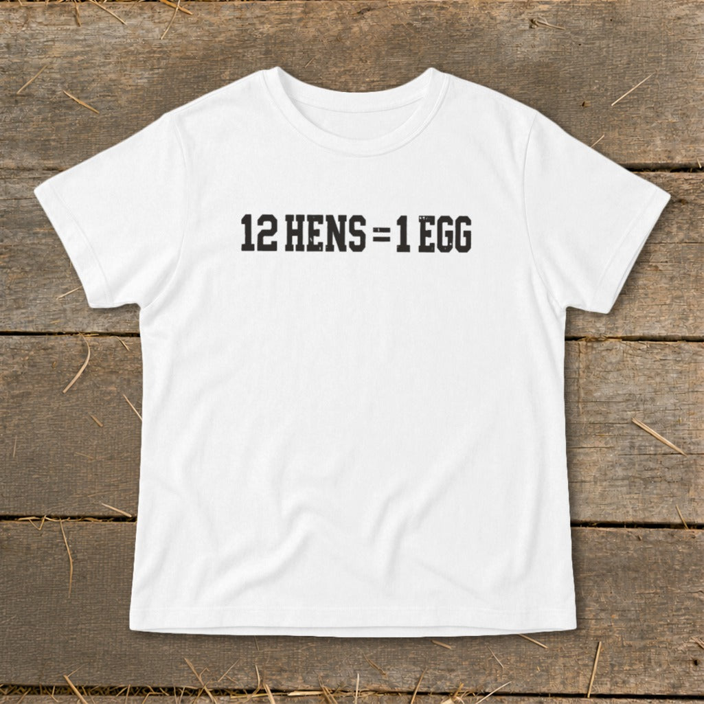 White short-sleeved t-shirt with black block lettering reading 12 HENS = 1 EGG laid on wood.
