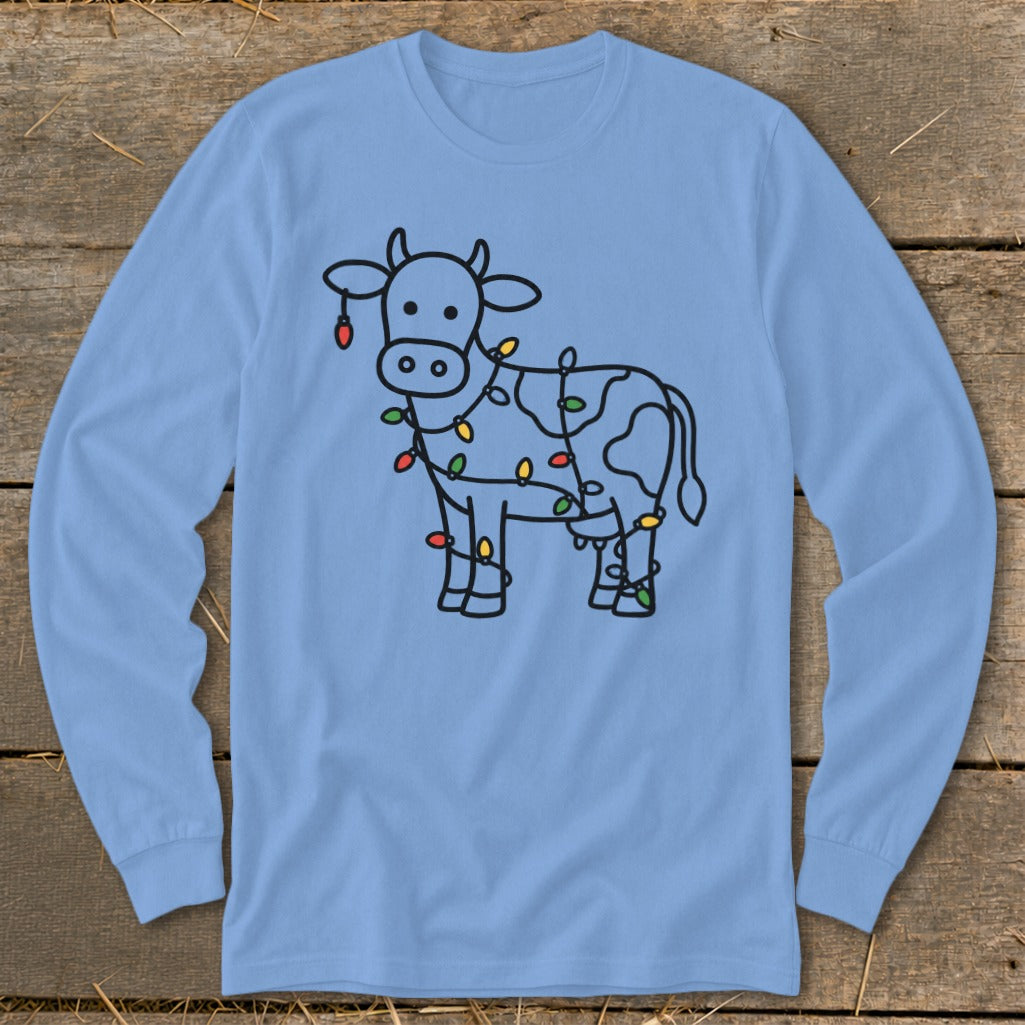 Line drawing of a cow decorated with colorful Christmas lights on a light blue long-sleeve shirt.