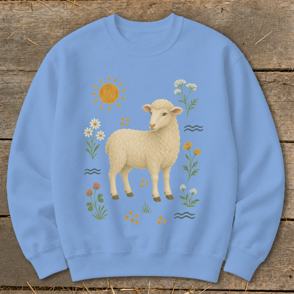 Light blue sweatshirt with a cream sheep, sun, and wildflowers illustration.