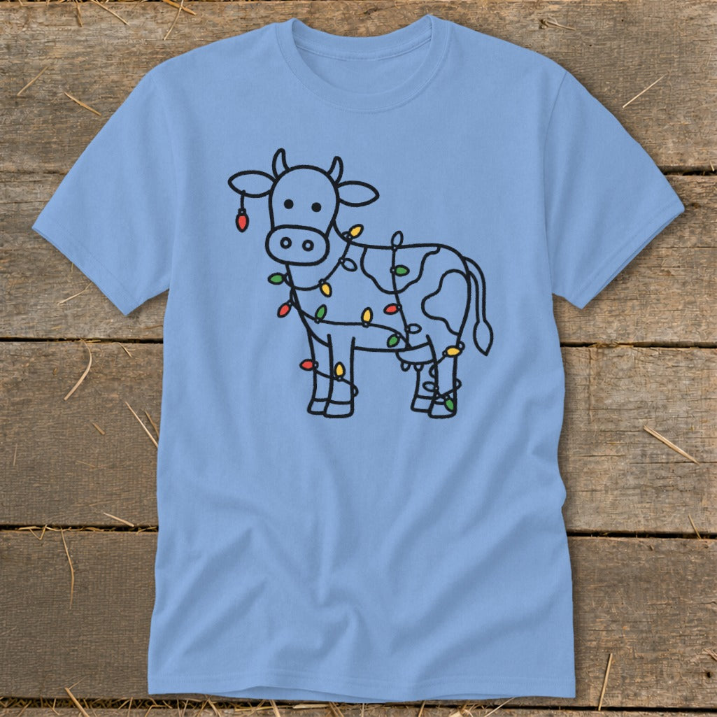 Light blue t-shirt with a black line drawing of a cow wrapped in Christmas lights.