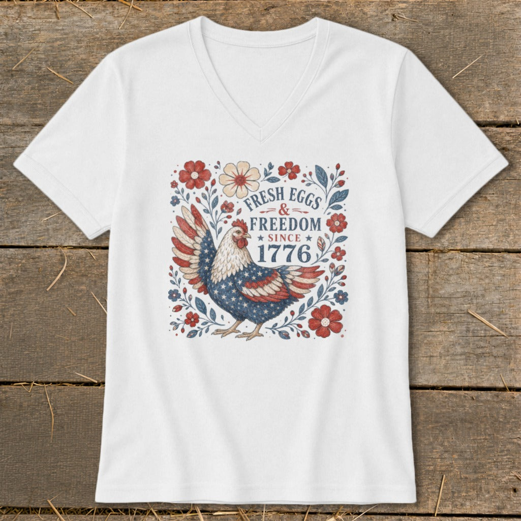 White v-neck t-shirt with patriotic chicken and "Fresh Eggs & Freedom Since 1776" text.