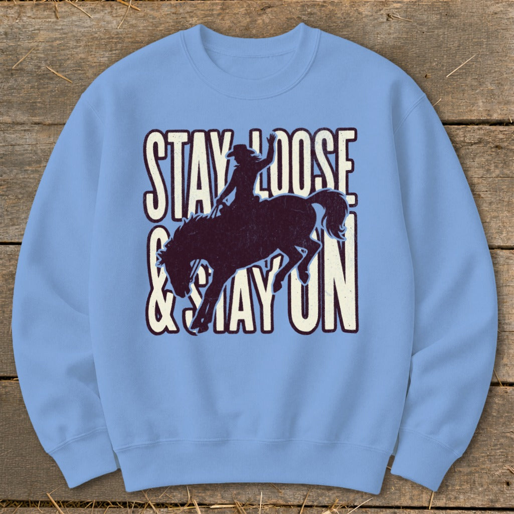 Light blue sweatshirt with distressed cowboy riding horse graphic and text.
