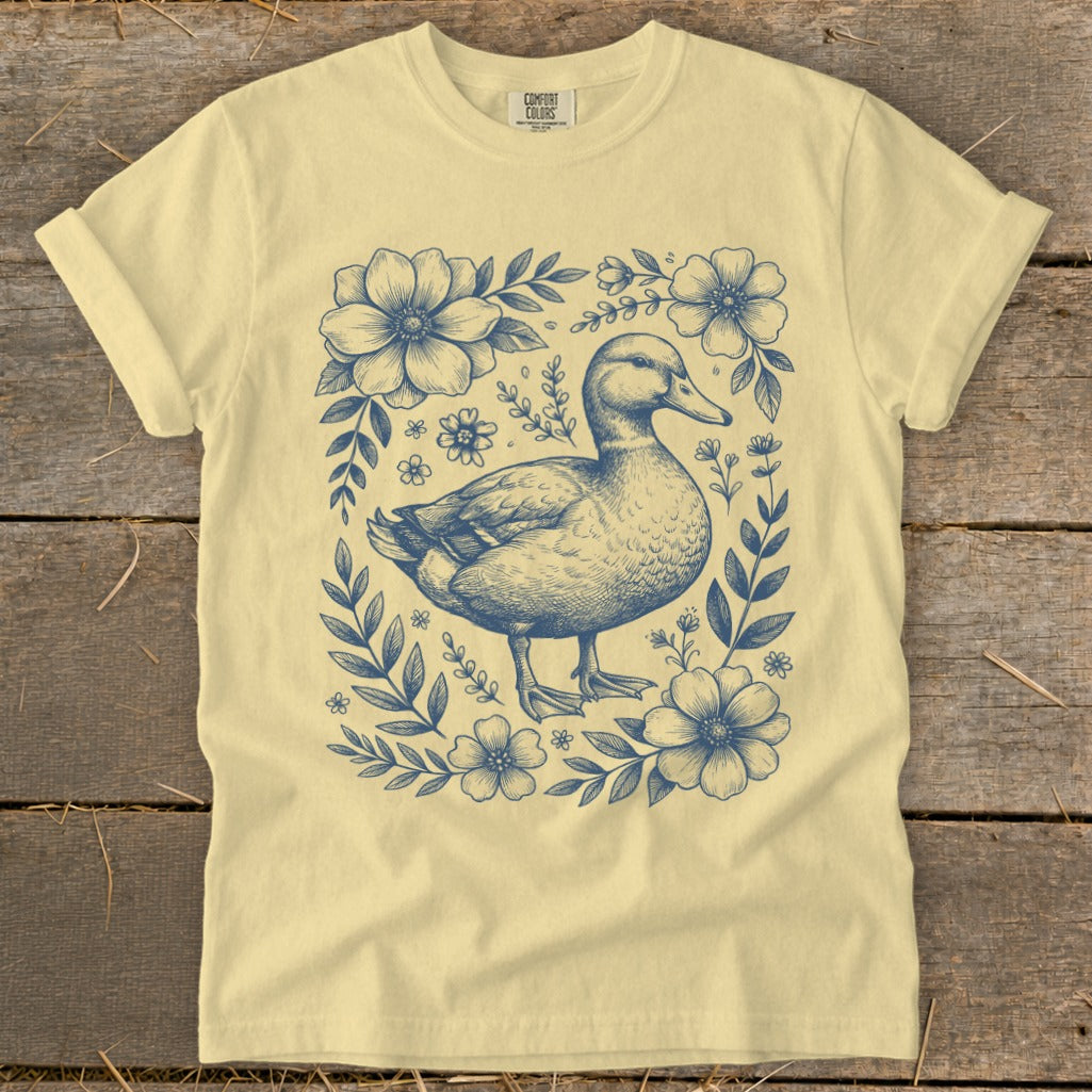 Light yellow t-shirt with a blue duck and floral sketch design.
