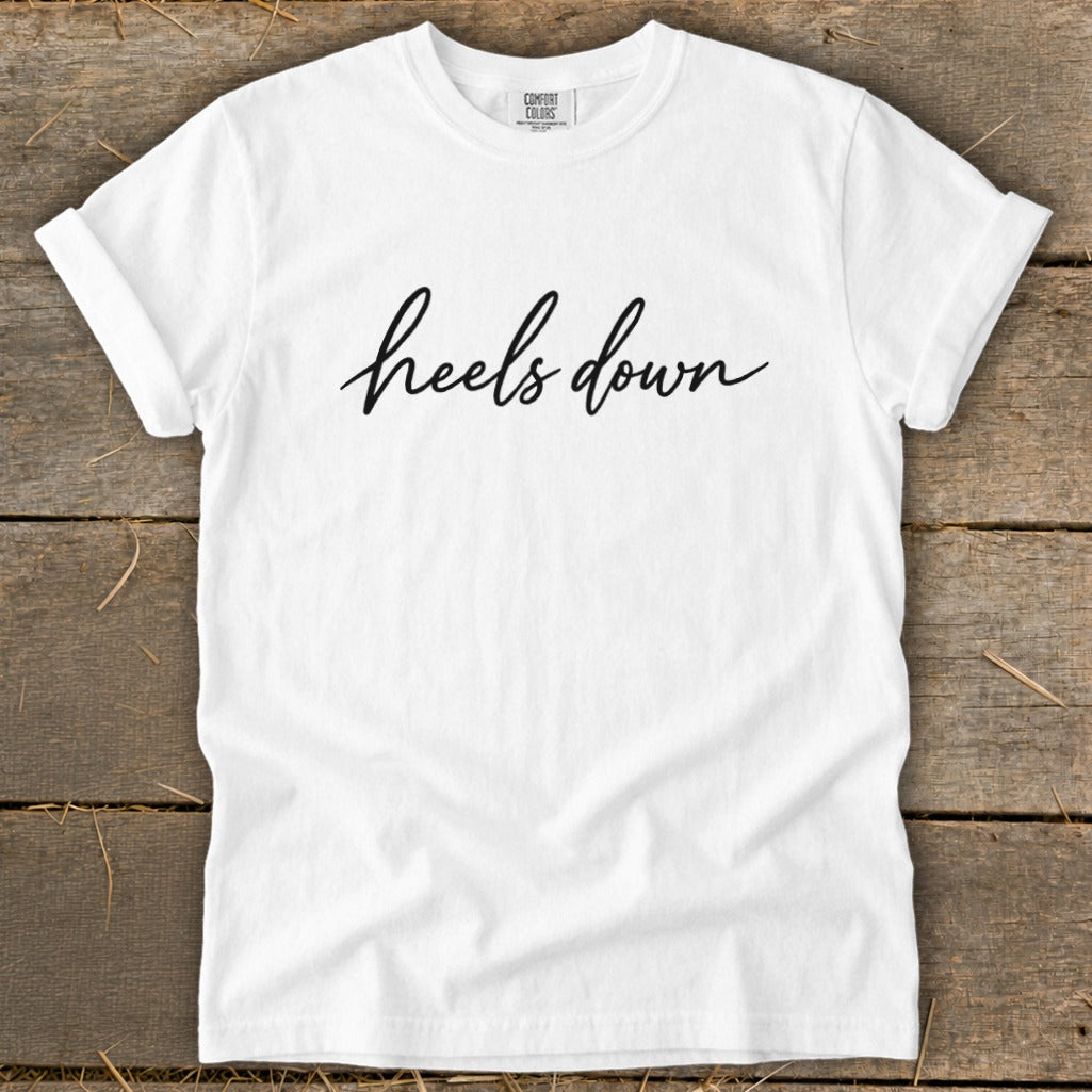 White t-shirt with "heels down" in black cursive text.
