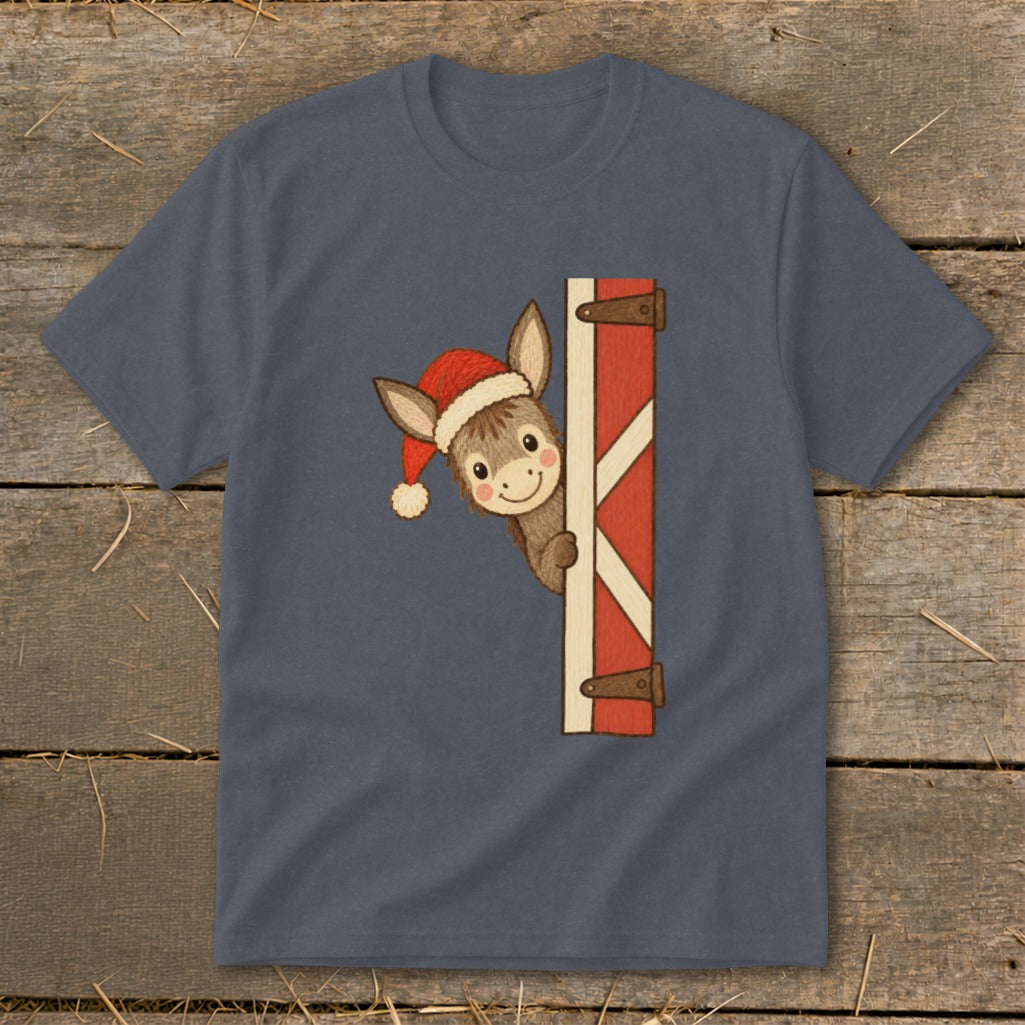 Donkey wearing a Santa hat peeking from behind a red barn door.