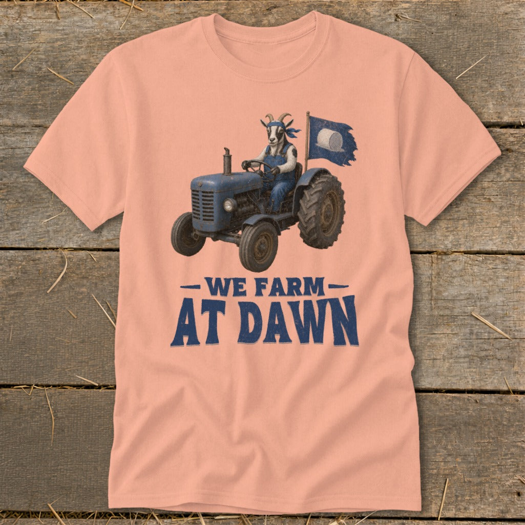 Goat driving a tractor on a shirt with text "WE FARM AT DAWN".