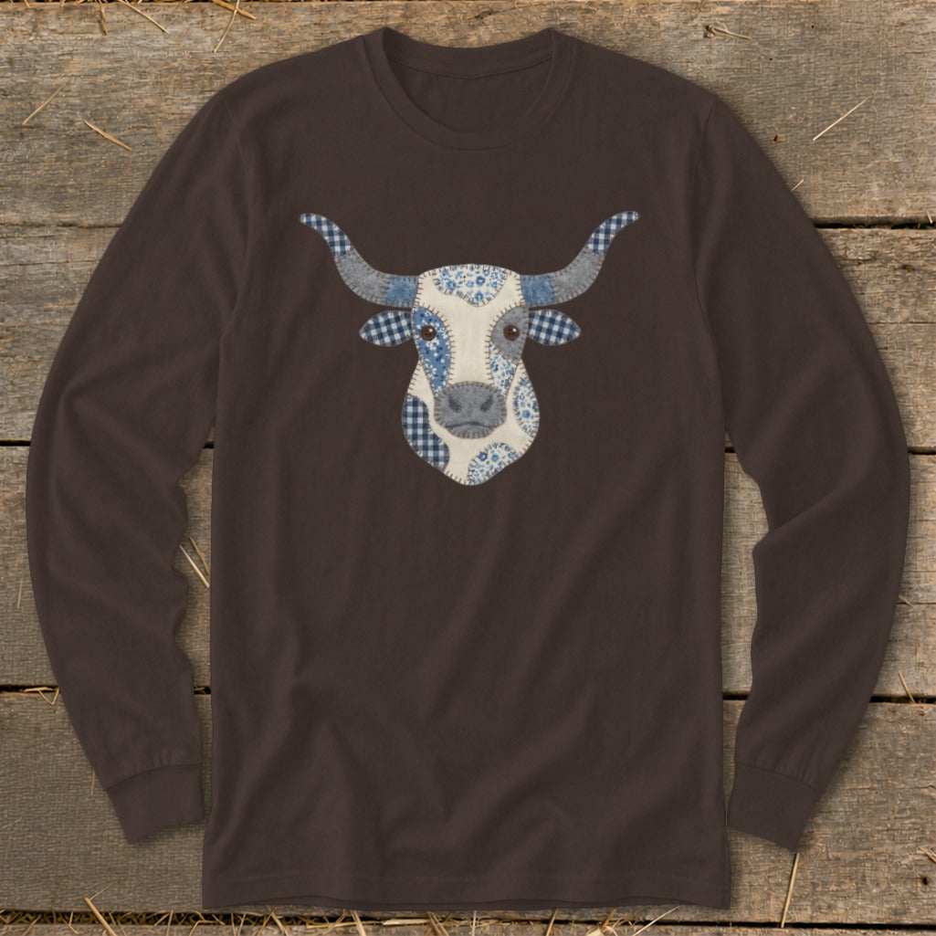 Brown long-sleeve shirt with a patchwork cow face design featuring blue and white patterns.