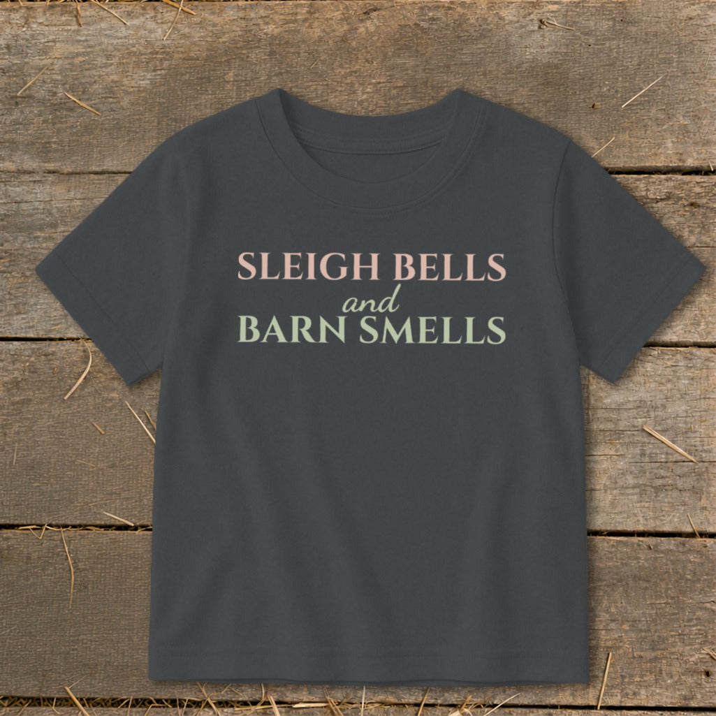 Dark grey t-shirt with "Sleigh Bells and Barn Smells" text in pastel colors.
