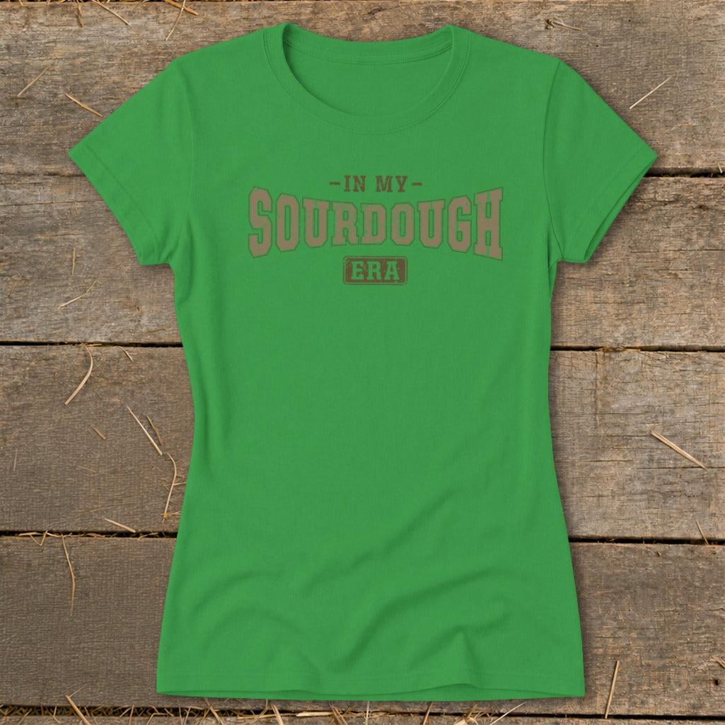 Green t-shirt with "In My Sourdough Era" graphic text on a wooden background.