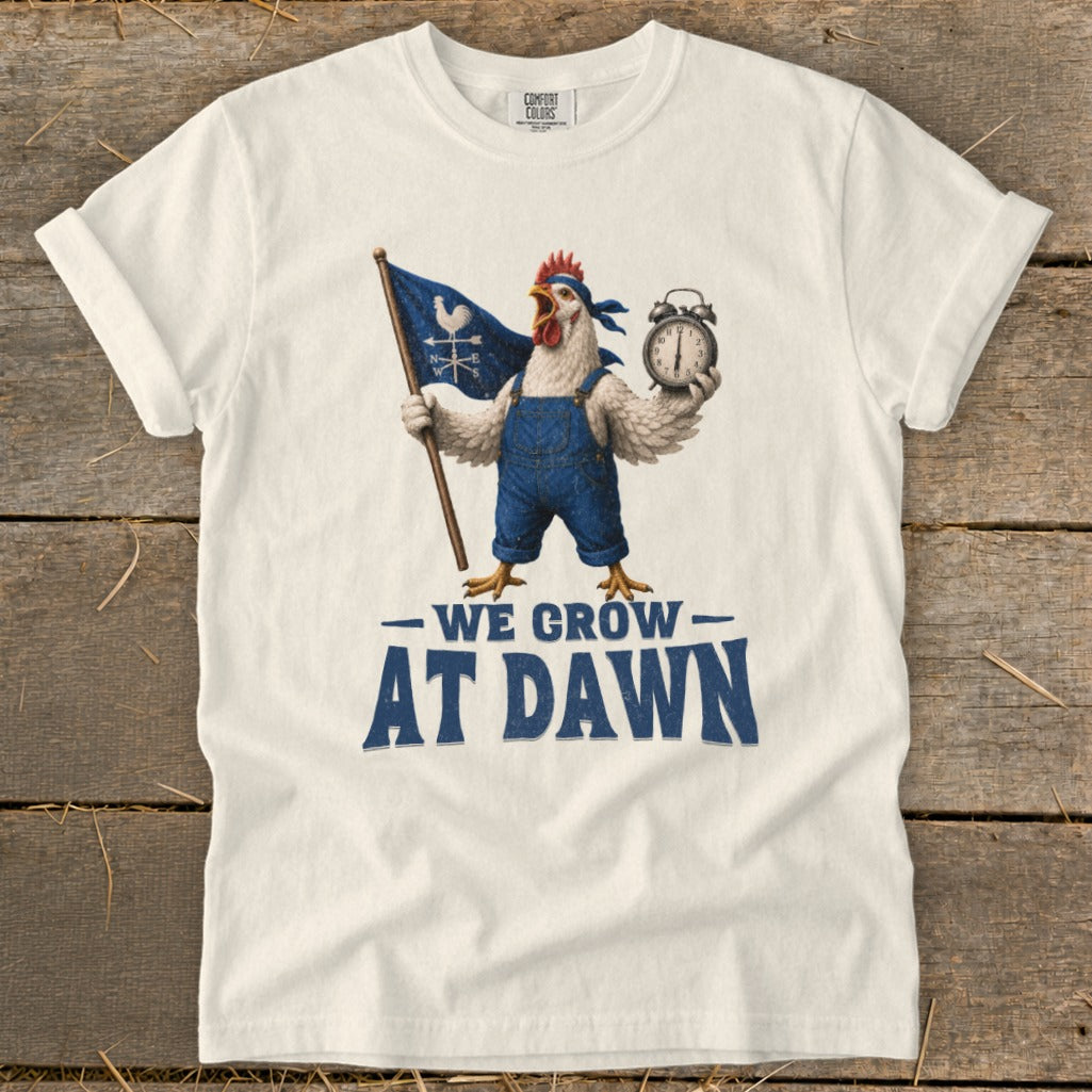 Chicken in overalls holding flag and alarm clock with text "We Grow At Dawn".