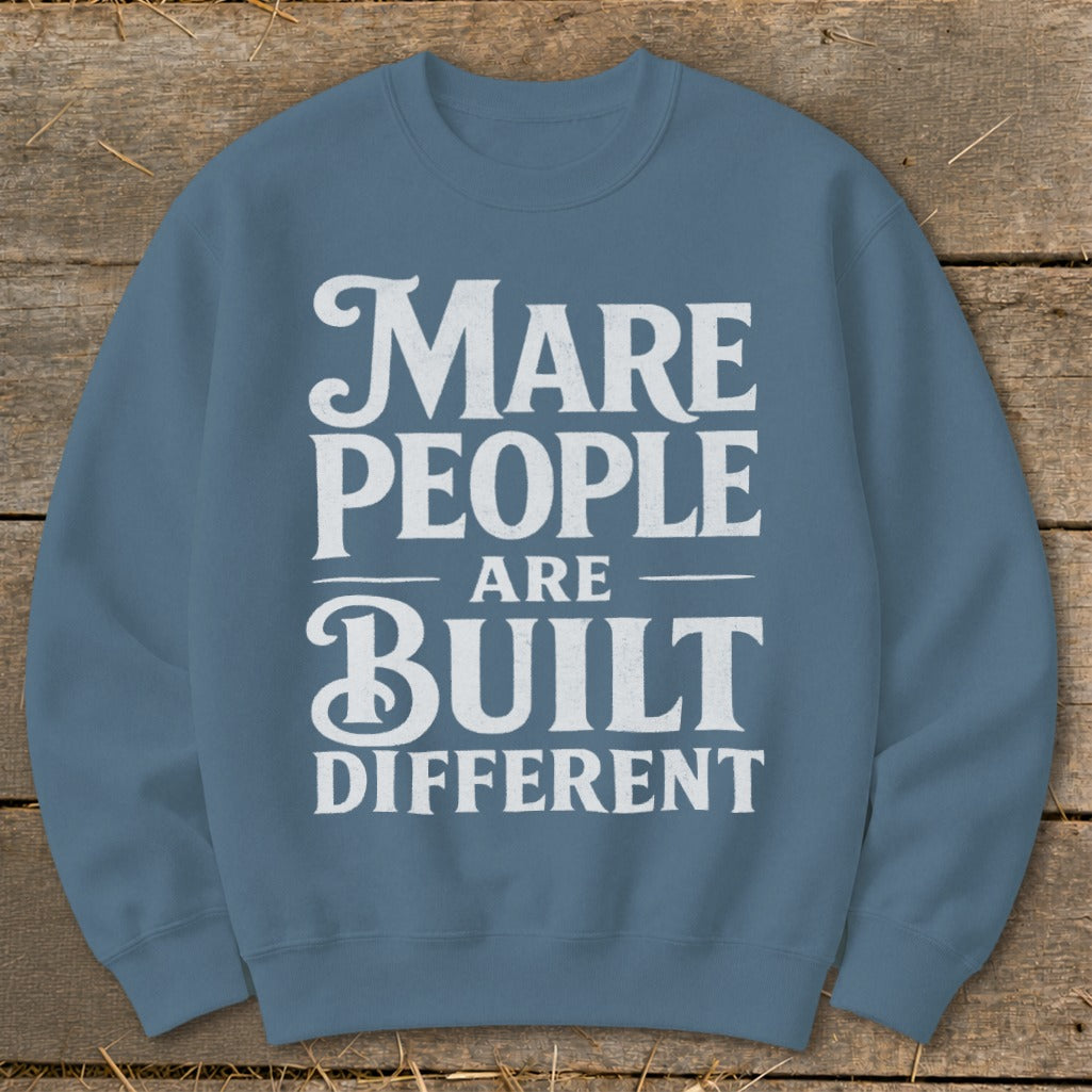 Blue sweatshirt with white text: "Mare People Are Built Different"