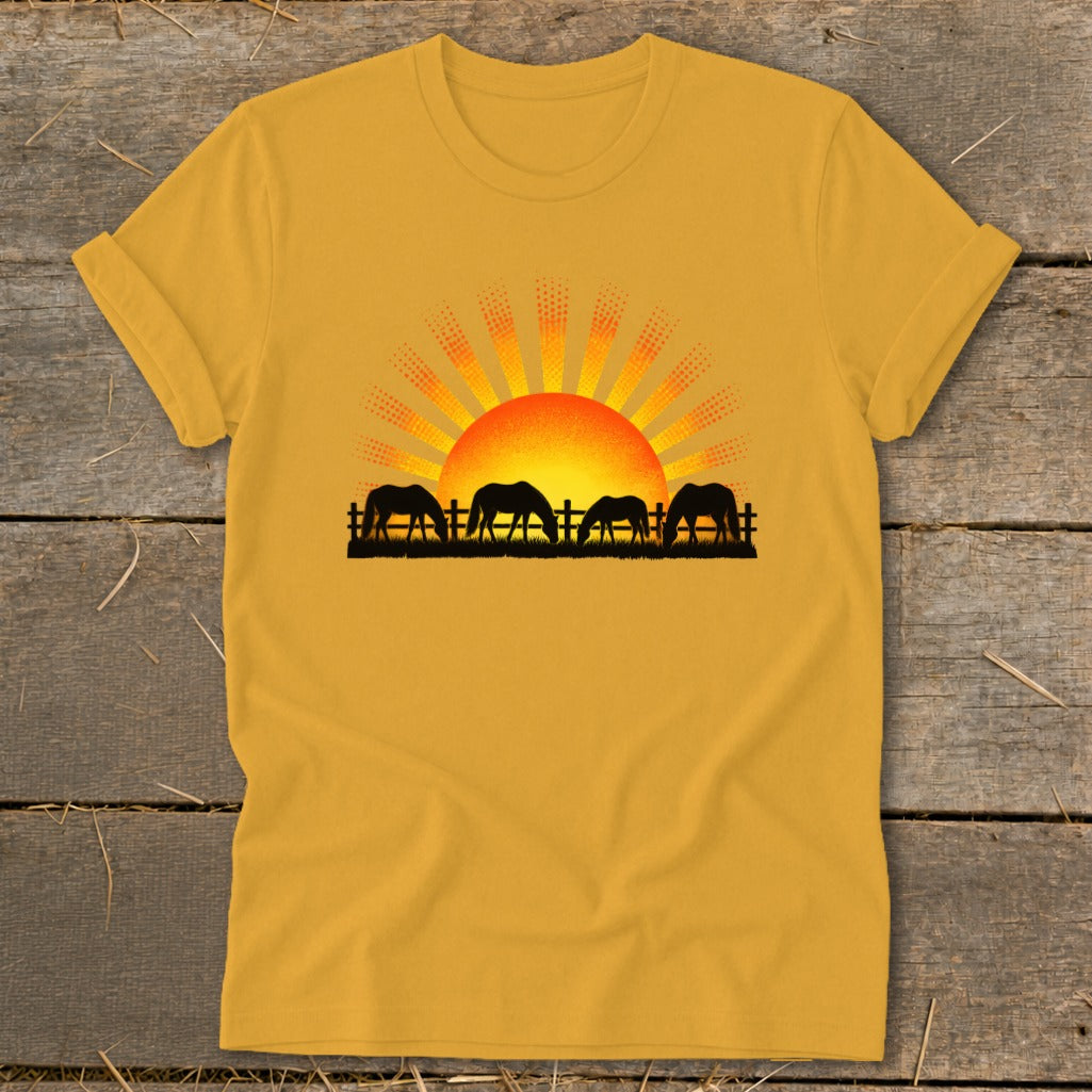Yellow t-shirt with four horses grazing in front of a sunrise graphic.