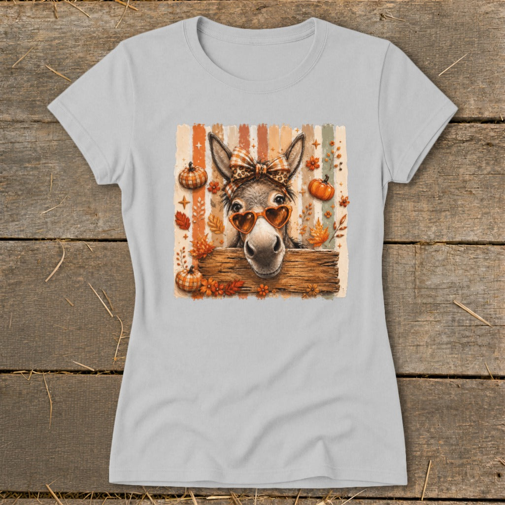 Donkey wearing heart sunglasses and bow, surrounded by pumpkins and fall leaves.