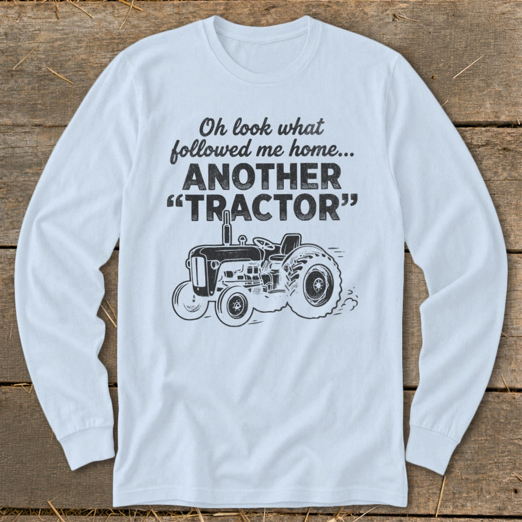 Light blue long sleeve shirt with "Oh look what followed me home... ANOTHER 'TRACTOR'" and tractor graphic.