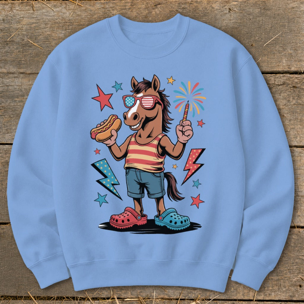 Horse in sunglasses holding hot dog and sparkler, wearing striped shirt and shorts.