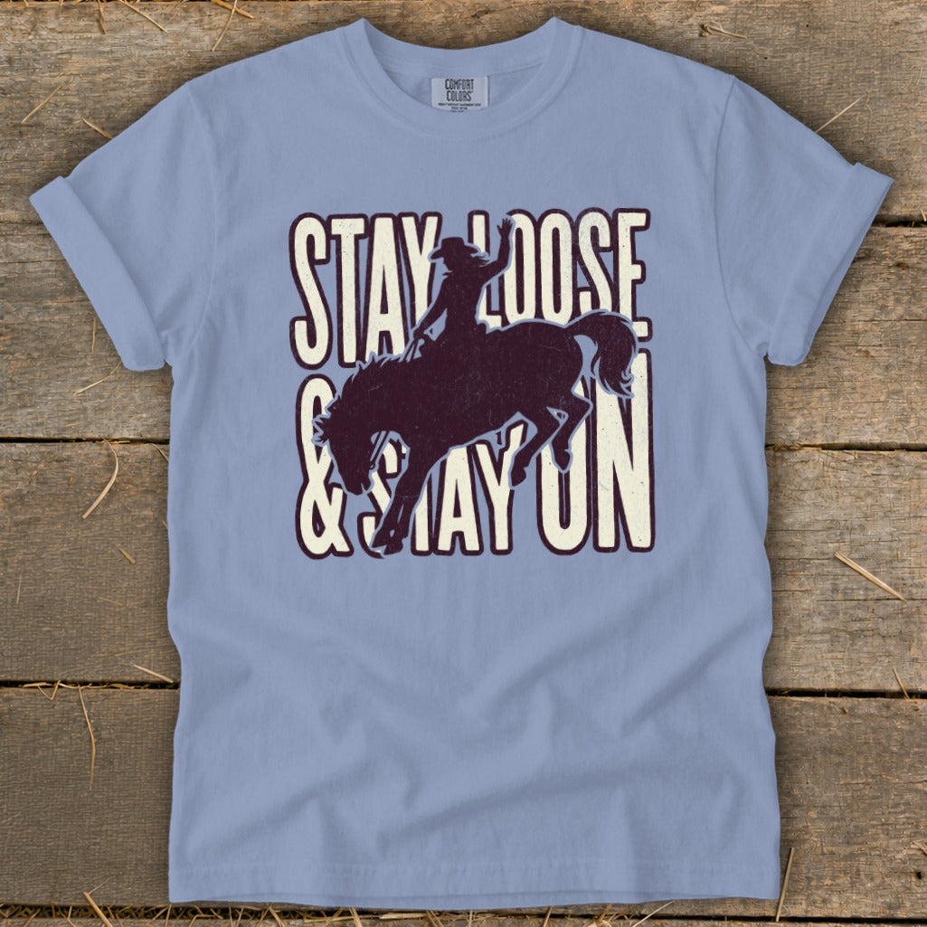 Light blue t-shirt with "STAY LOOSE & STAY ON" and a bucking bronco graphic.