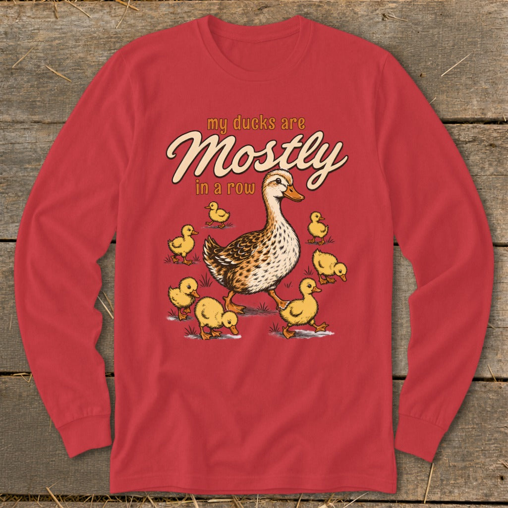 Red long-sleeve shirt with cartoon ducks and the text "my ducks are Mostly in a row".