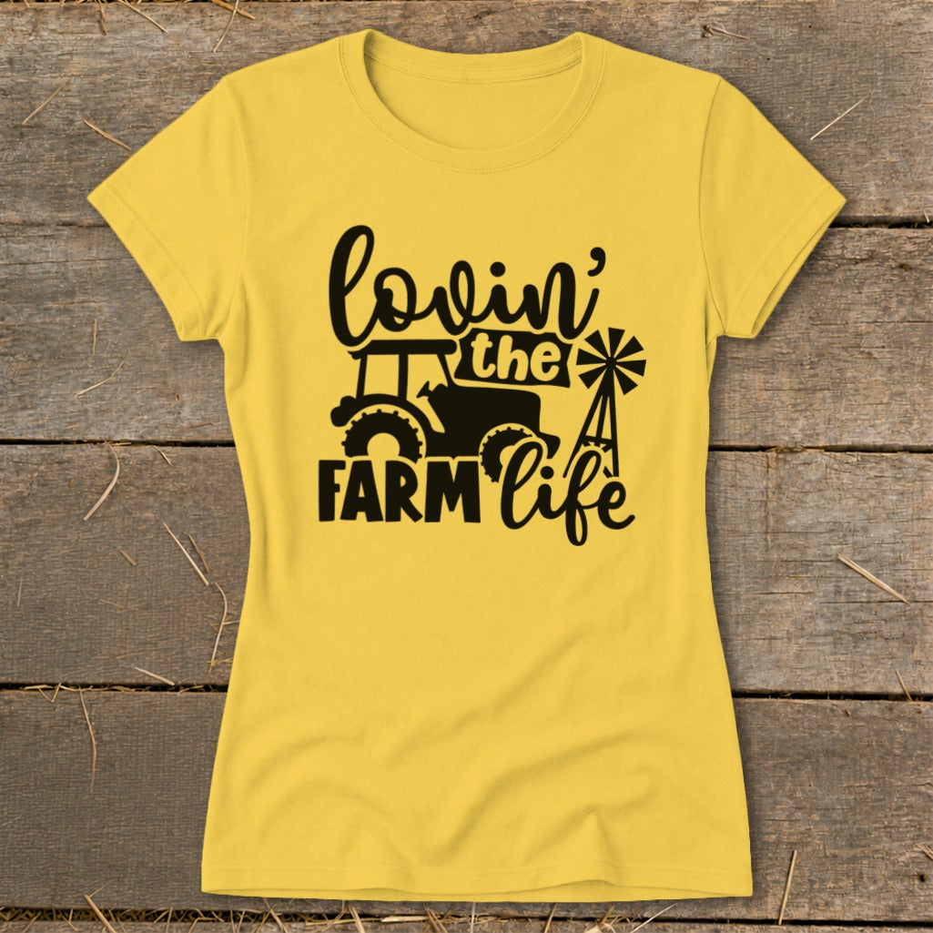 Yellow t-shirt with black "lovin' the farm life" text, tractor, and windmill graphic.