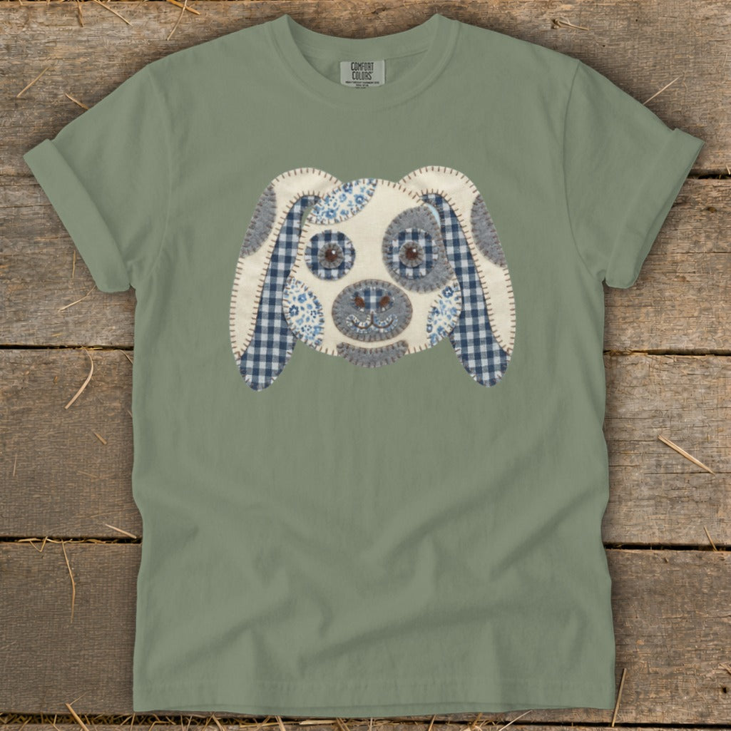Green t-shirt with a patchwork dog face applique featuring gingham and floral patterns.