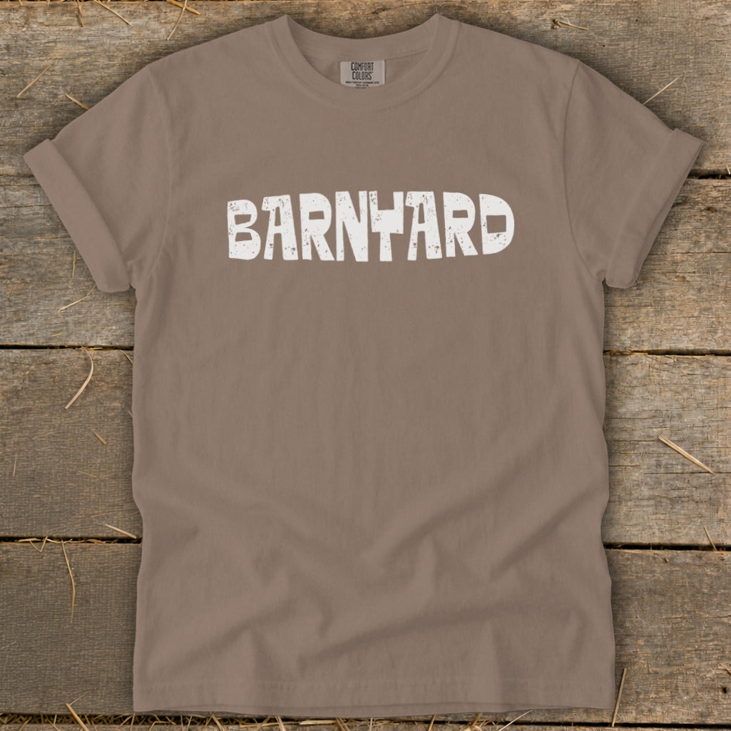 Brown crew neck t-shirt with rolled sleeves featuring the word BARNYARD in distressed white capital letters across the chest.