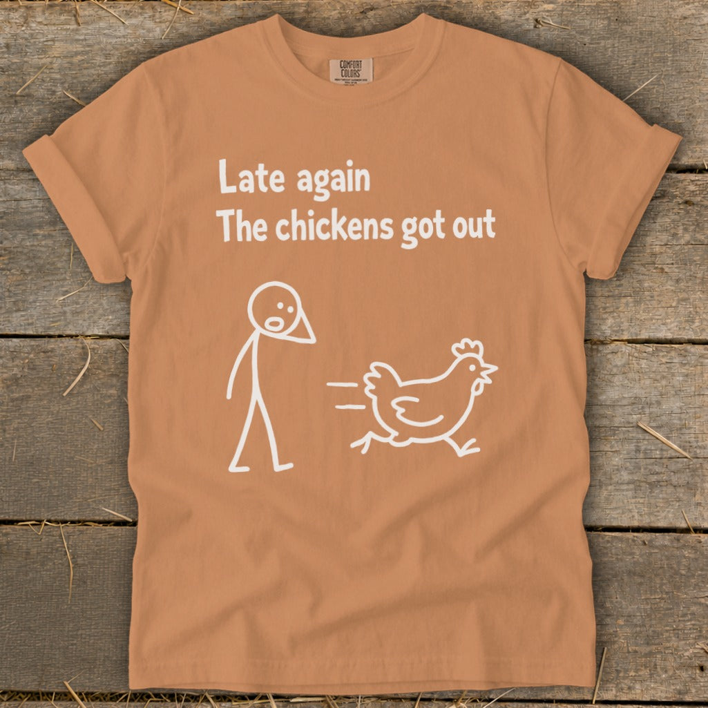 Orange t-shirt with white text "Late again the chickens got out" and a stick figure chasing a chicken.