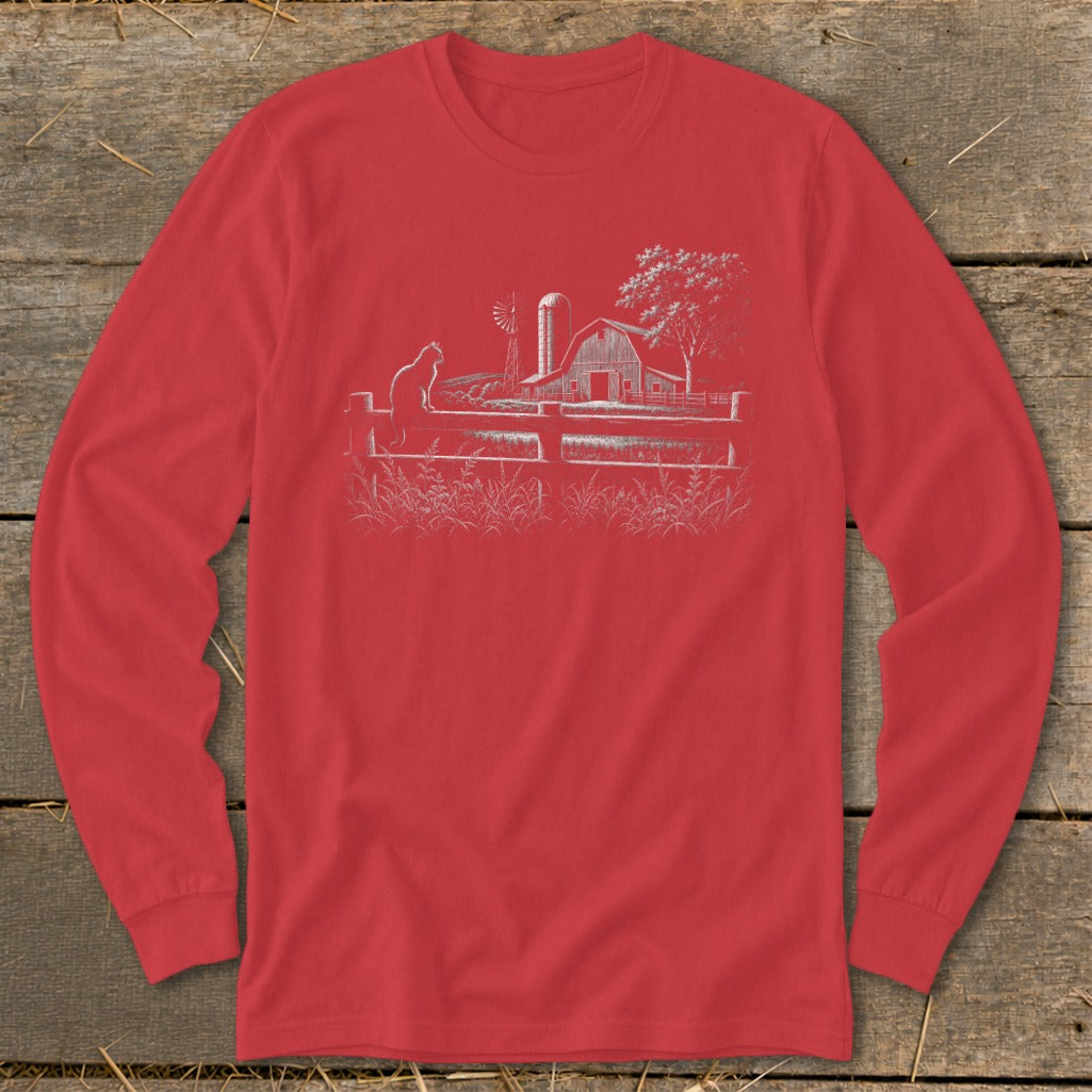 Red long-sleeved shirt with a white line drawing of a farm scene and a cat.