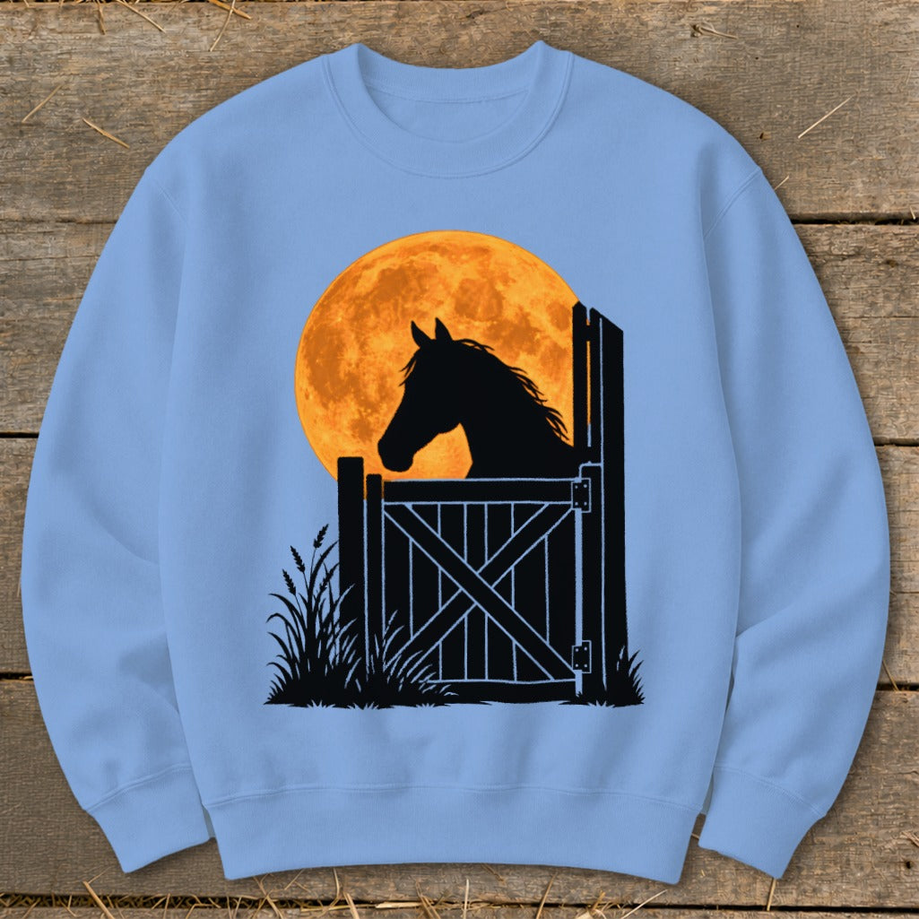 A light blue crewneck sweatshirt featuring a graphic of a horse looking out a stable door against a large orange moon.