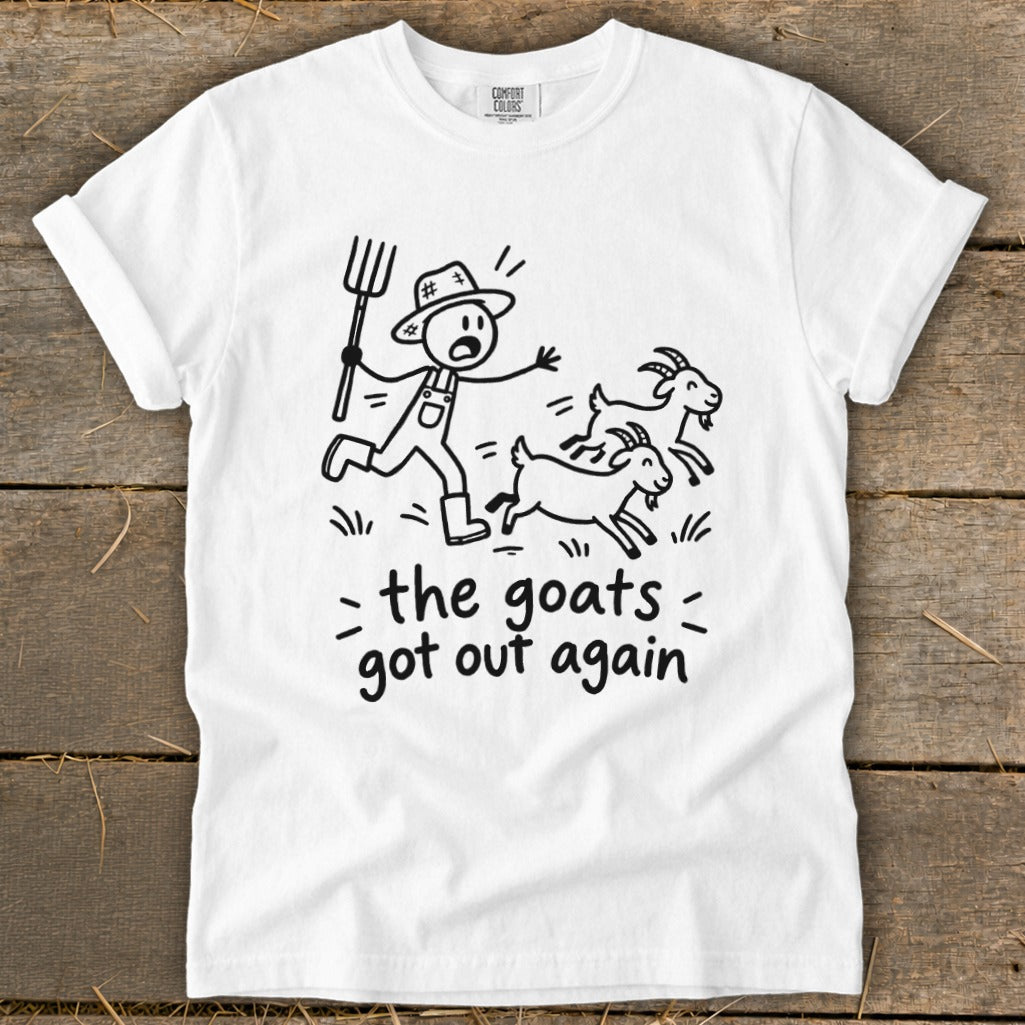 White t-shirt with cartoon of farmer chasing escaped goats and text "the goats got out again".