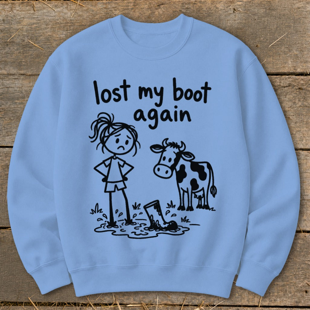 Light blue crewneck sweatshirt featuring a graphic of a sad stick figure, a cow, and the text lost my boot again.
